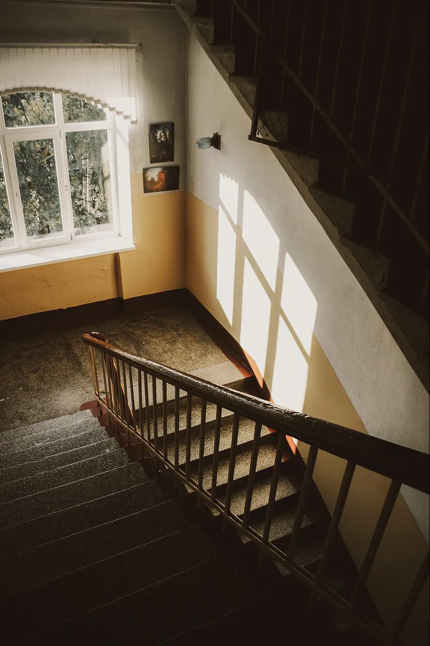 A timber stair turning in warm sideways light