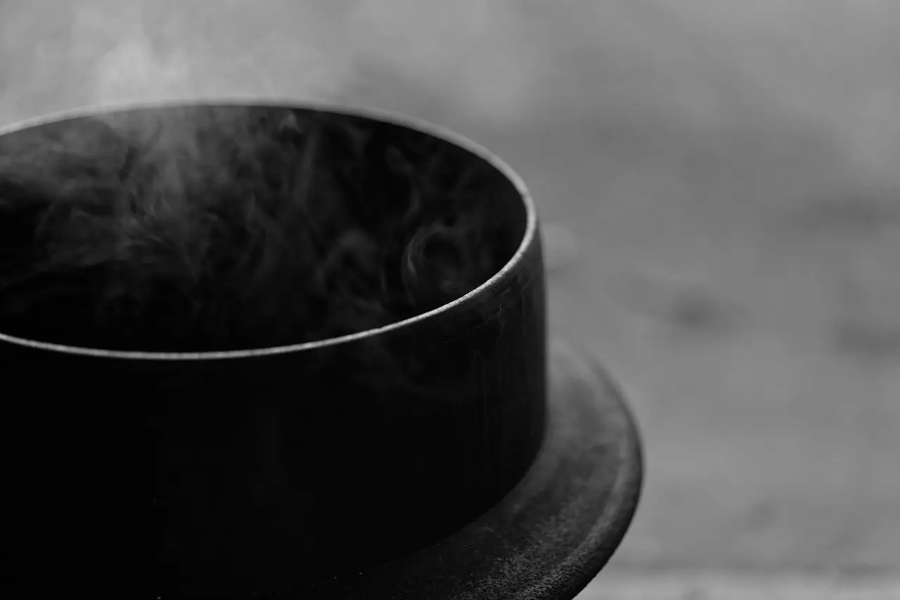 Steam rising from a dark tea bowl