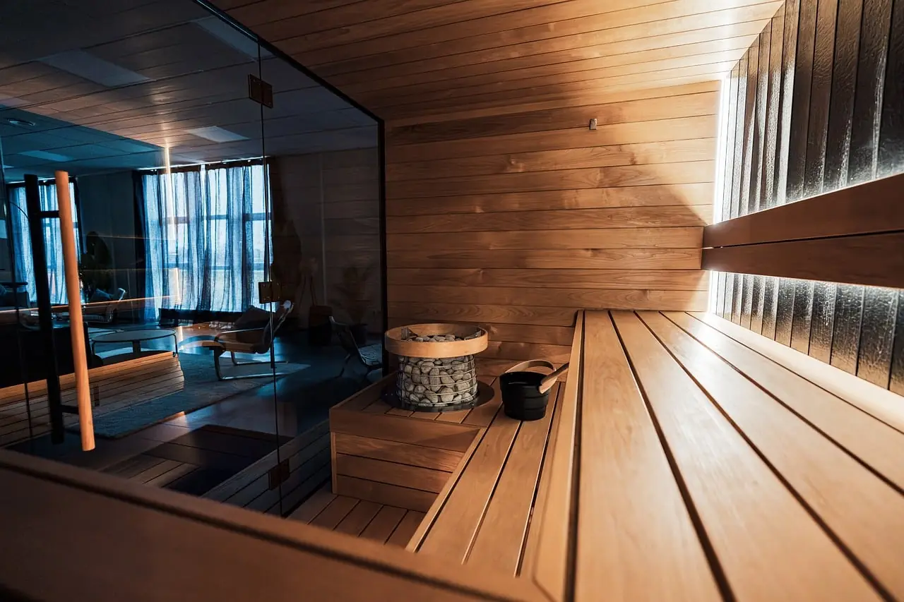 Cedar sauna benches under low light and drifting steam